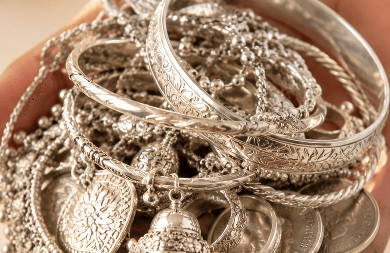 Silver jewellery held in a hand
